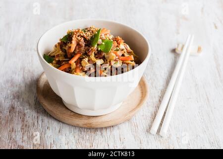 Baguettes et bol de riz rouge frit avec légumes Banque D'Images