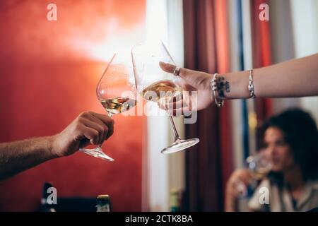 Image rognée d'amis qui toaster des lunettes de vin pendant la fête à la maison Banque D'Images