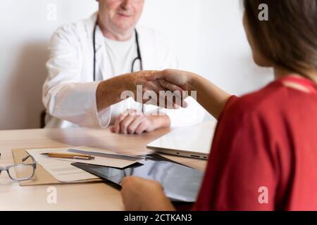 Doctor shaking hand with patient in clinic Banque D'Images