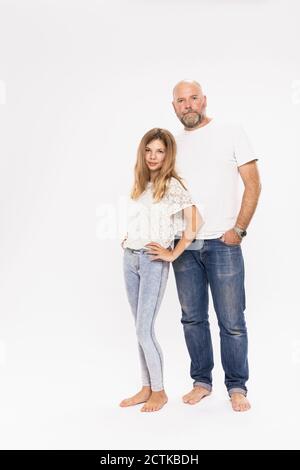 Père avec fille posant tout en se tenant sur fond blanc Banque D'Images