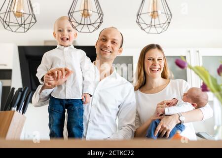Les parents sourient tout en tenant leurs bébés garçons à la maison Banque D'Images