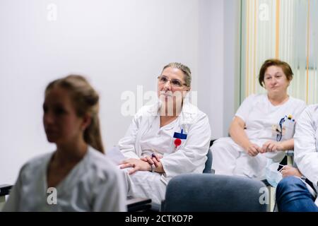 Des femmes médecins écoutent pendant qu'elles sont assises à l'hôpital Banque D'Images