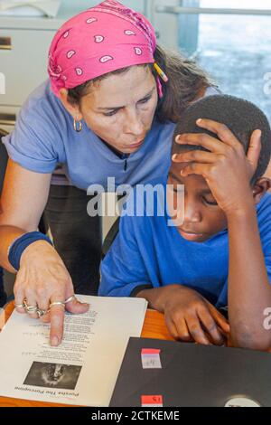 Miami Florida, Coconut Grove Shake A Leg Summer Day Camp activités, étudiants lit la lecture femme enseignante enseignante conseillère pédagogique, salle de classe bo Banque D'Images