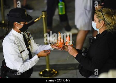 Washington, États-Unis. 23 septembre 2020. L'agent de police de la Cour suprême des États-Unis gère les souvenirs commémoratifs laissés par les amateurs de deuil qui paient leur respect alors que la juge Ruth Bader Ginsburg se trouve en repos sous le Portico, au sommet des marches avant de l'édifice de la Cour suprême des États-Unis, le mercredi 23 septembre 2020, à Washington. Ginsburg, 87 ans, est décédé d'un cancer le 18 septembre. (AP photo/Andrew Harnik, Pool) crédit : UPI/Alay Live News Banque D'Images