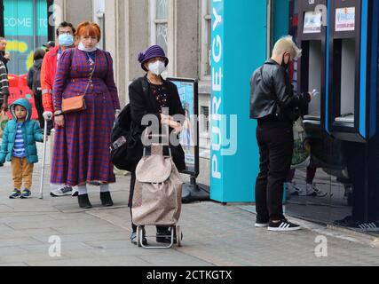 Les personnes portant des masques font la queue pour utiliser une machine à billets à l'extérieur d'une banque à Camden.les membres du public portant des masques protecteurs lorsqu'ils magasinent dans le centre de Londres, car d'autres mesures de verrouillage sont proposées pour la capitale plus tard cette semaine. Le gouvernement britannique se prépare à un éventuel second confinement à l'échelle nationale pour lutter contre la propagation de la COVID-19. Banque D'Images