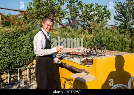 Orvieto, région de l'Ombrie, Italie. Chef dans un restaurant qui sert des grillades à l'extérieur. (À usage éditorial uniquement) Banque D'Images