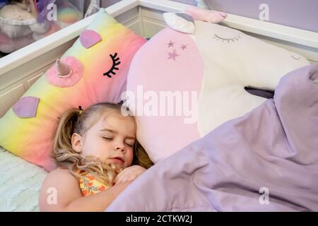 Lily, 3 ans, prétendant s'endormir en elle lit Banque D'Images