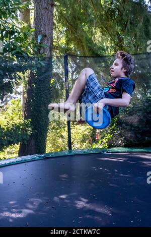 Lynwood, Washingtin, États-Unis. un garçon de 17 ans rebondit et se retourne sur son trampoline. Banque D'Images