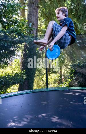 Lynwood, Washingtin, États-Unis. un garçon de 17 ans rebondit et se retourne sur son trampoline. Banque D'Images