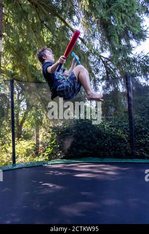 Lynwood, Washingtin, États-Unis. un garçon de 17 ans rebondit et se retourne sur son trampoline. Banque D'Images