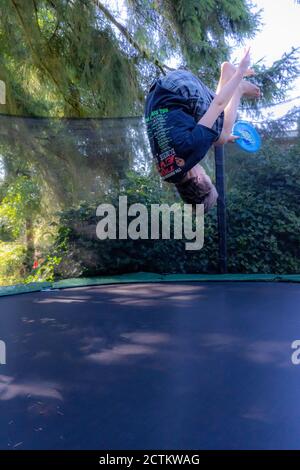 Lynwood, Washingtin, États-Unis. un garçon de 17 ans rebondit et se retourne sur son trampoline. Banque D'Images