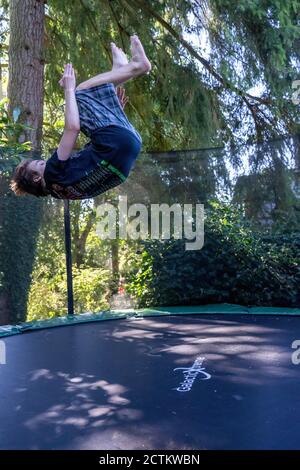 Lynwood, Washingtin, États-Unis. un garçon de 17 ans rebondit et se retourne sur son trampoline. Banque D'Images