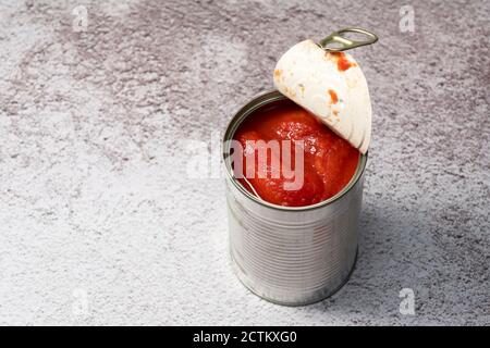 Boîtes de tomates entières sur fond de pierre Banque D'Images