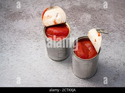 Boîtes de tomates entières sur fond de pierre Banque D'Images