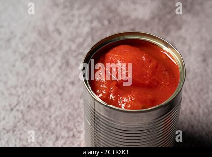 Boîtes de tomates entières sur fond de pierre Banque D'Images