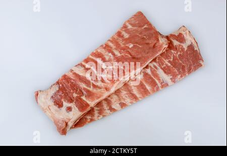 Côtes de porc non cuites isolées sur fond blanc. Vue de dessus. Banque D'Images