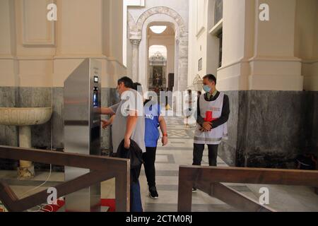 Les fidèles visitant la cathédrale, pendant les célébrations du patron Saint-Matthieu, sont mesurés la température corporelle avec un instrument totem Banque D'Images