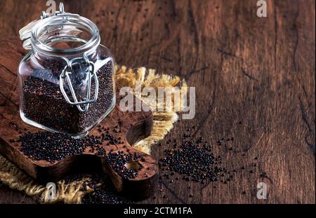 Graines de quinoa noir dans un bol sur une table rustique en bois Banque D'Images