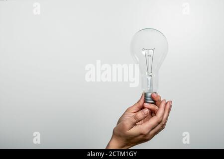 Ampoule dans les mains d'une femme. Espace libre pour le texte et l'espace de copie. Banque D'Images