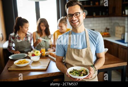 Groupe d'amis heureux s'amuser en cuisine, cuisiner ensemble Banque D'Images