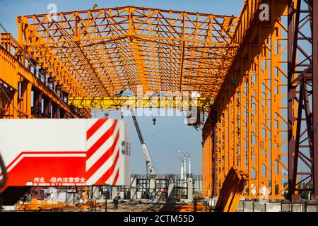 Kostanay/Kazakhstan - Mai 14 2012: Construction d'une nouvelle usine de construction structure en acier orange. Grue et deux crochets de grue en arrière-plan. Petit travailleur Banque D'Images