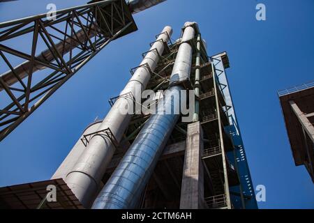 Mynaral/Kazakhstan - avril 23 2012 : usine moderne de ciment Jambyl. Le silo et les tuyaux sur ciel bleu clair. Objectif grand angle. Banque D'Images