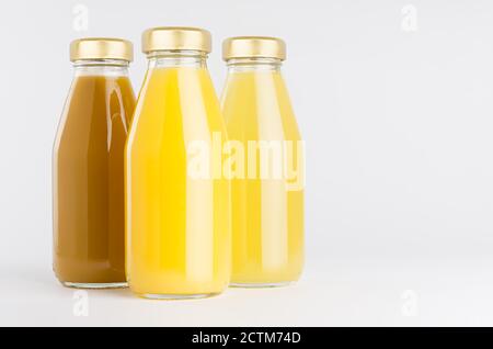 Maquette de la collection de jus de fruits orange et jaune en bouteilles de verre avec bouchon, gros plan, groupe sur fond blanc, modèle d'emballage, publicité, de Banque D'Images