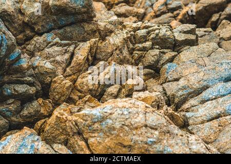 Gros plan vif orange vif brun jaune pierre roche en buis falaise fissures texture montagnes. Concept de géologie, pouvoir de beauté dans la nature. Naturel Banque D'Images