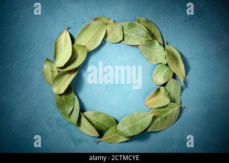 Cadre culinaire avec un lieu pour le texte. Une couronne de feuilles de Laurier, tiré depuis le haut sur un fond bleu Banque D'Images