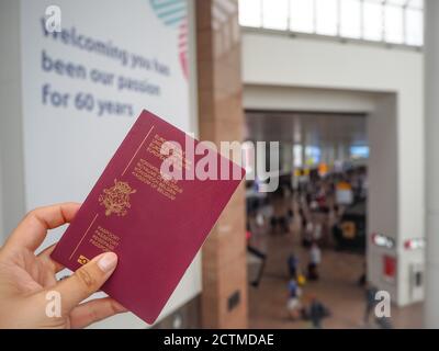 Août 2018 - Zaventem, Belgique : main blanche féminine détenant un passeport belge au hall d'enregistrement de l'aéroport de Bruxelles, l'aéroport principal de Belgique Banque D'Images