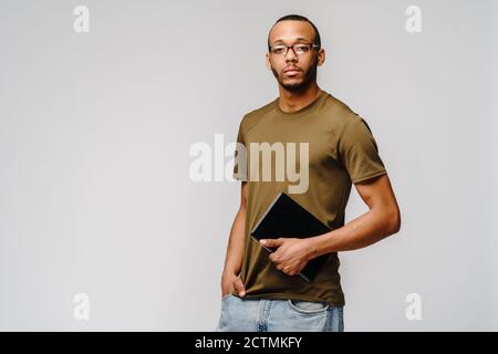 Portrait d'un jeune homme afro-américain portant un t-shirt vert tenant le coussinet de tablette pc Banque D'Images