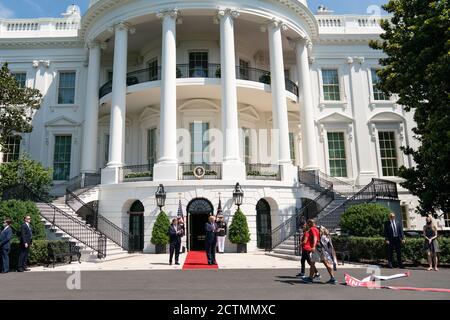 Le président Trump se réjouit de la marche maritime à la Maison Blanche. Le président Donald J. Trump et le secrétaire aux anciens combattants Robert Wilkie accueillent la deuxième Dame Karen Pence et le Marine américaine Terry Sharpe le lundi 27 juillet 2020, sur la pelouse sud de la Maison Blanche. M. Sharpe a marché de la Caroline du Nord à Washington D.C. pour sensibiliser les vétérans aux suicides. Banque D'Images