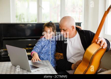 grand-père enseigner fille jouant le piano heureusement Banque D'Images