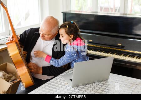 grand-père enseigner fille jouant le piano heureusement Banque D'Images