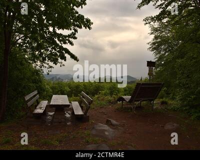 Aire de pique-nique humide avec bancs en bois et table après la pluie, vue sur la forêt du Palatinat, mystérieux wafts de brume et temps nuageux près de Dahn. Banque D'Images