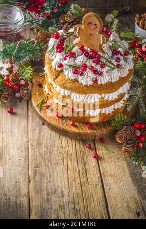 Gâteau de Noël festif au pain d'épice avec fromage à la crème fouettée, biscuits aux canneberges et au pain d'épice, fond en bois avec texte de décoration de noël Banque D'Images