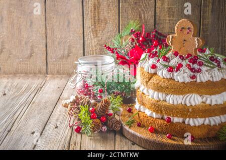 Gâteau de Noël festif au pain d'épice avec fromage à la crème fouettée, biscuits aux canneberges et au pain d'épice, fond en bois avec texte de décoration de noël Banque D'Images