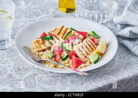 Salade Bulgur appétissante avec melon d'eau et concombres dans un plat servi sur table pour un délicieux déjeuner Banque D'Images