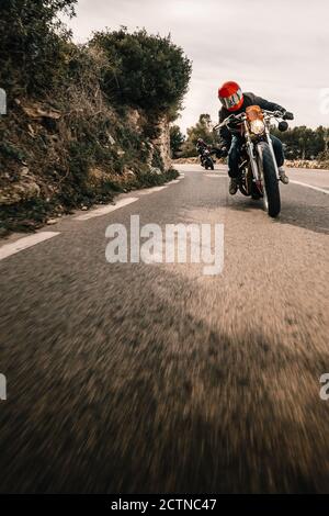 motards non reconnaissables qui conduisent des motos sur une route asphaltée étroite traverser un terrain montagneux Banque D'Images