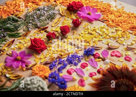 Gros plan de boutons de fleurs parfumés et de pétales délicats disposés sur table rustique en bois Banque D'Images