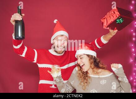 Couple heureux célébrant les vacances de Noël - les jeunes s'amusent boire et rire pendant l'événement de noël Banque D'Images