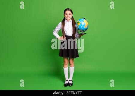 Photo portrait d'une fille tenant le globe d'une main l'autre taille isolée sur fond vert vif Banque D'Images