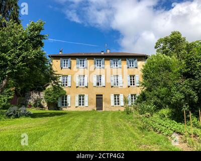 Ancien manoir français avec volets et pelouse, dans les collines accidentées de l'Ariège Banque D'Images