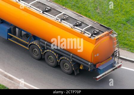 Grande remorque-citerne orange camion roulant sur autoroute Banque D'Images