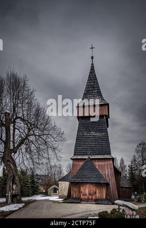 Unique église en bois du XVIIe siècle à Bialka Tatrzanska. Nuages sombres et sombres et ciel spectaculaire. Montagnes Tatra, Pologne Banque D'Images