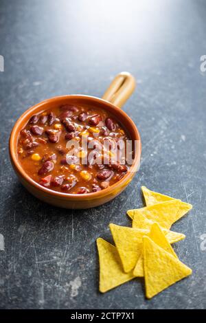 Croustilles au Chili con carne et à la tortilla. Cuisine mexicaine avec haricots sur table noire. Banque D'Images