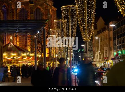 Hanovre, Allemagne, 21 décembre 2019 : illuminations de Noël devant le Marktkirche à Hanovre avec des gens qui passent à la hâte Banque D'Images