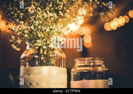Fleurs blanches de mariage dans un pot assis sur une table Banque D'Images
