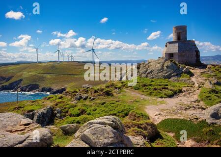 Vue sur les ruines de l'ancien phare de Vilán, avec des moulins à vent en arrière-plan, Galice, Espagne Banque D'Images