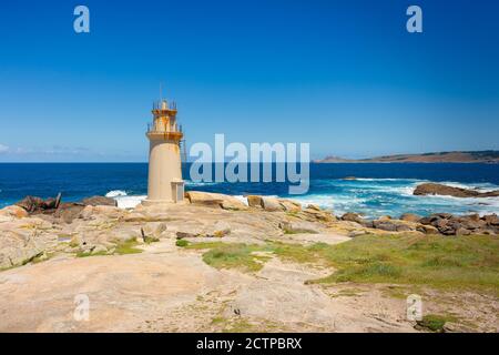 Vue sur le phare de Muxia Cape avec la pointe de Cabo Vilán en arrière-plan, Galice, Espagne Banque D'Images